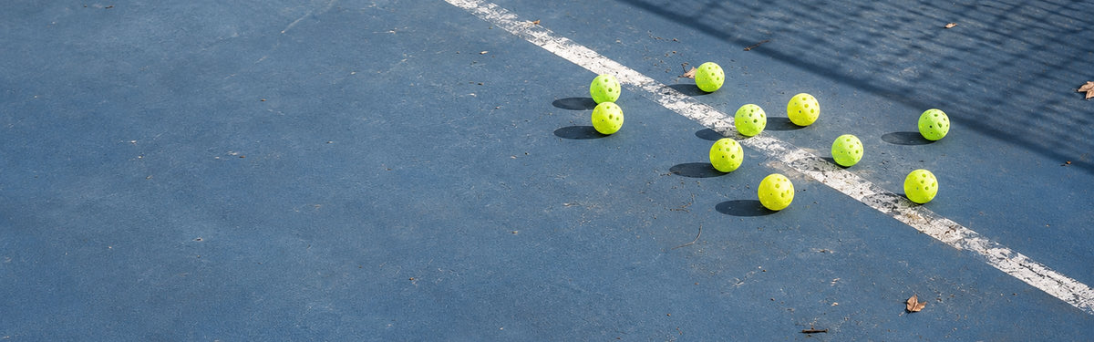 Neon pickleballs scattered along a court line