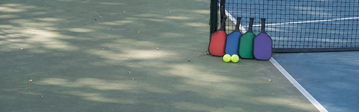 Paddles leaning in a row against the net